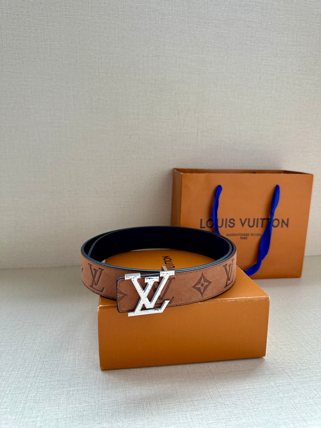 Louis Vuitton belt with monogram canvas and gold-tone LV buckle on orange gift box