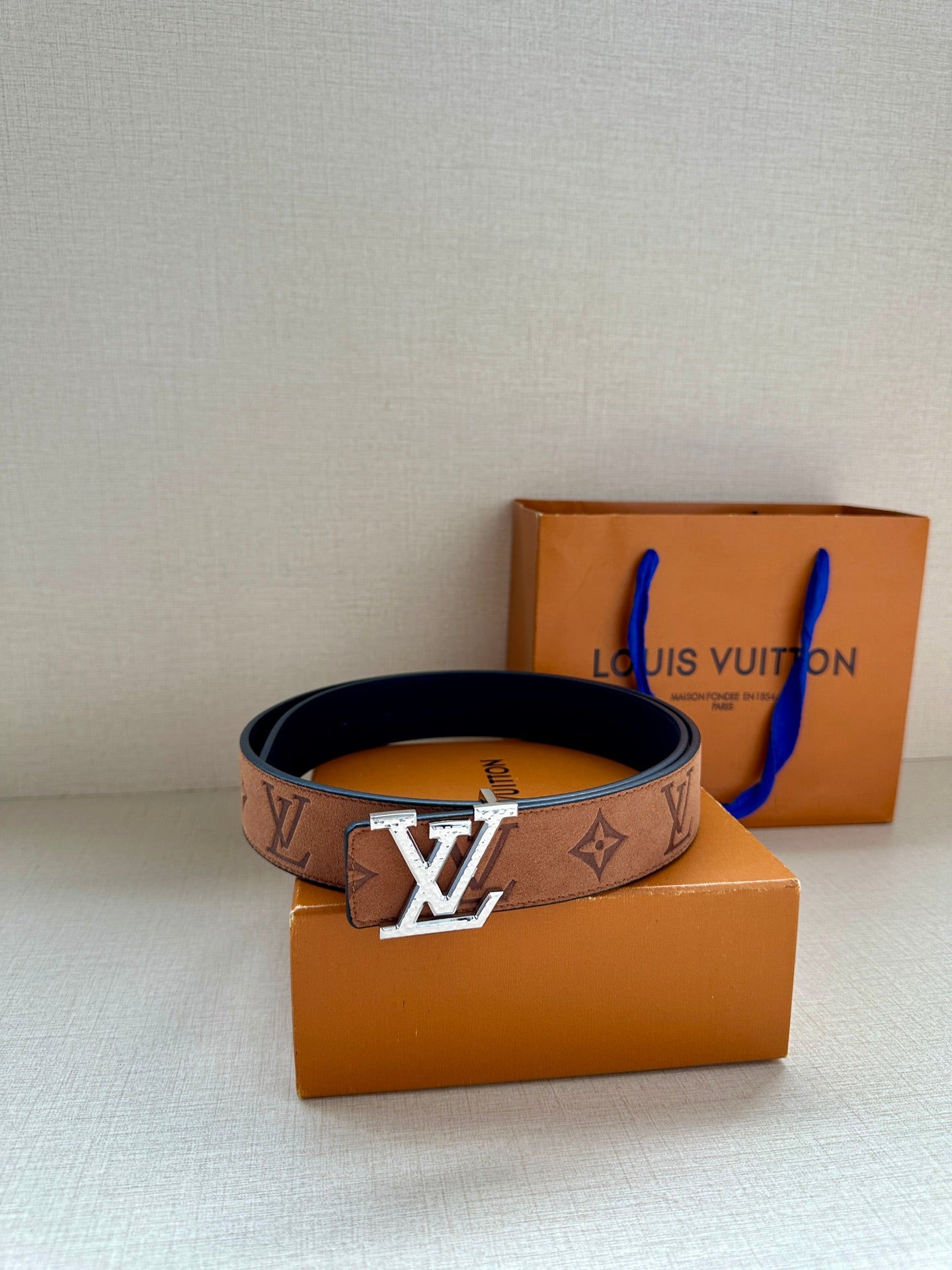 Louis Vuitton belt with monogram canvas and gold-tone LV buckle on orange gift box