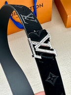 Monogram belt strap with dark finish and large silver-tone buckle, angled close-up