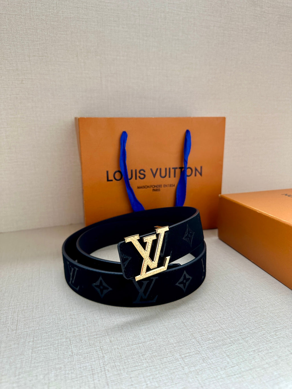 Monogram canvas belt with dark blue strap and gold-tone LV buckle centerpiece