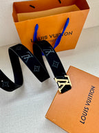 Monogram belt with long dark blue strap ends and silver-tone buckle, angled view