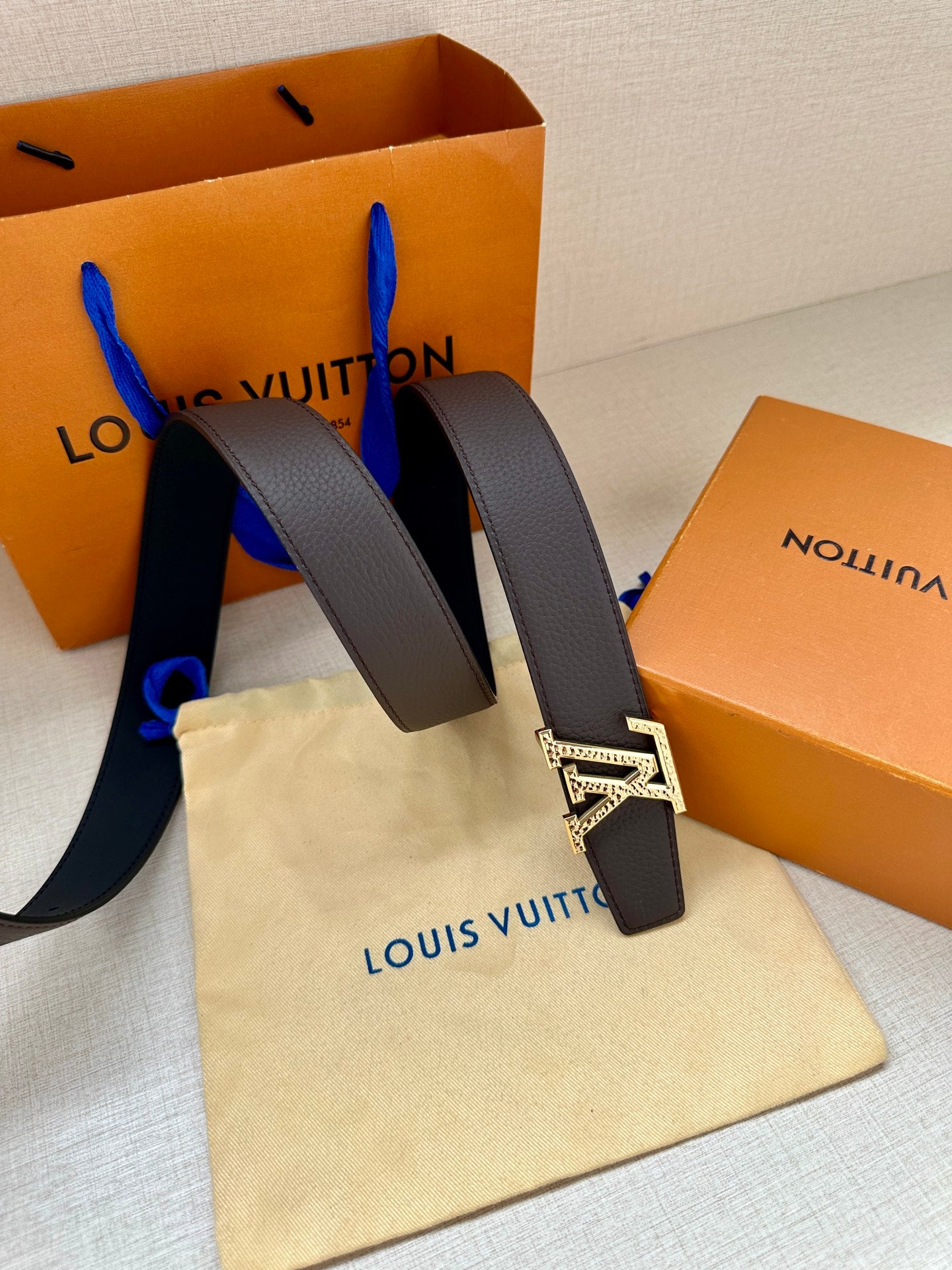 Louis Vuitton belt with dark leather straps and large silver-tone LV logo buckle