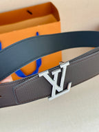 Louis Vuitton belt close-up showing dark leather strap and metal LV logo buckle