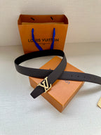 Louis Vuitton belt with dark strap and LV logo buckle resting on box and pouch
