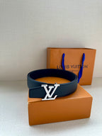 Dark blue leather belt with gold LV buckle, placed atop orange box.