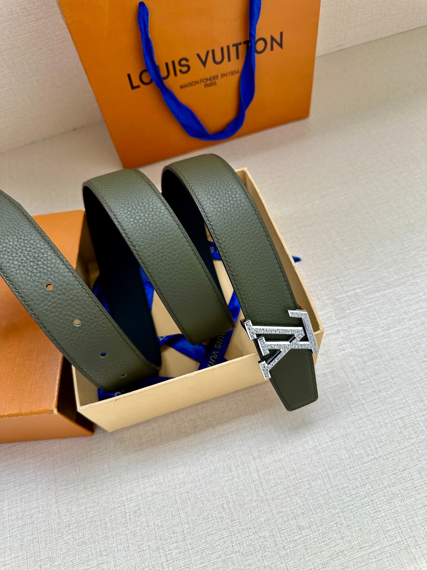 Pair of dark green leather belts with silver LV buckles