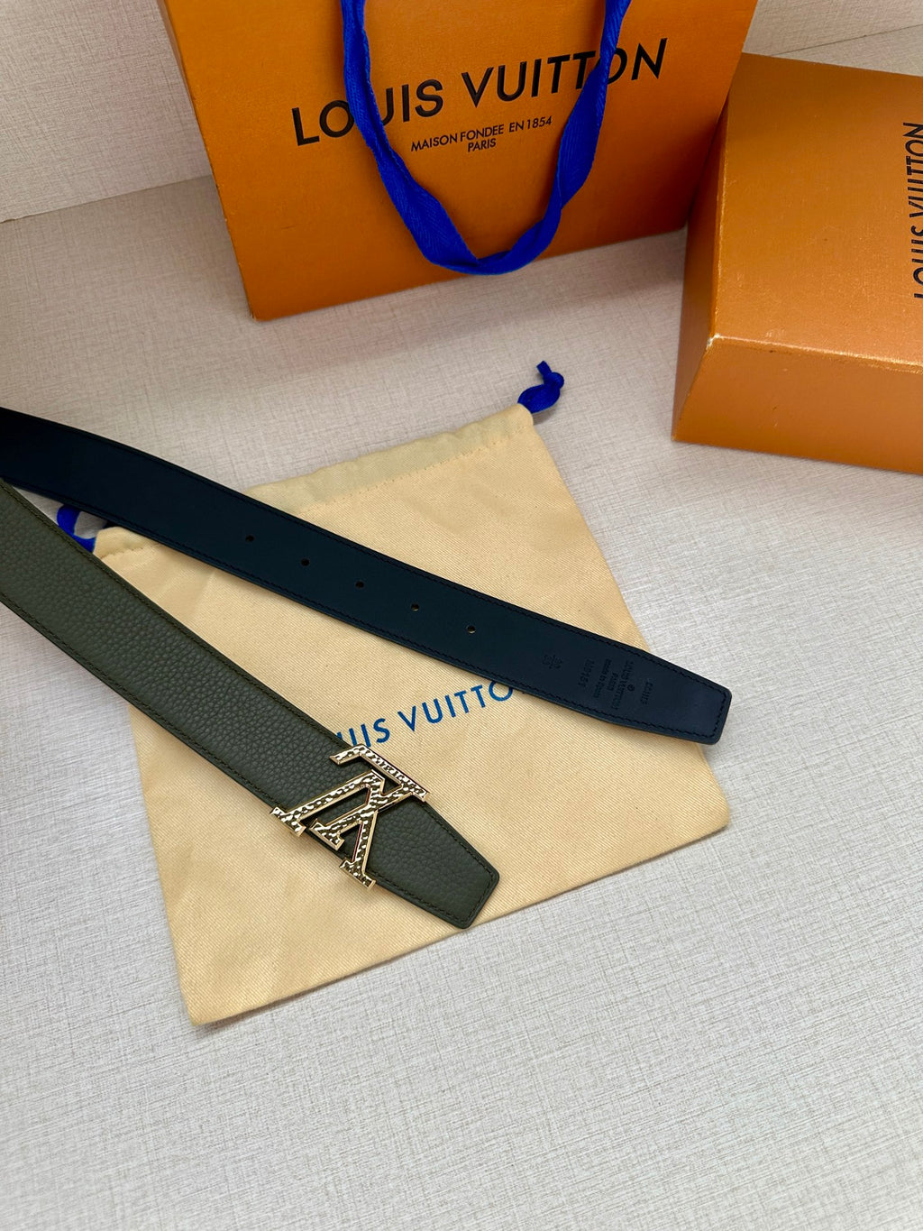 Two leather belts in dark and light green with silver LV buckles