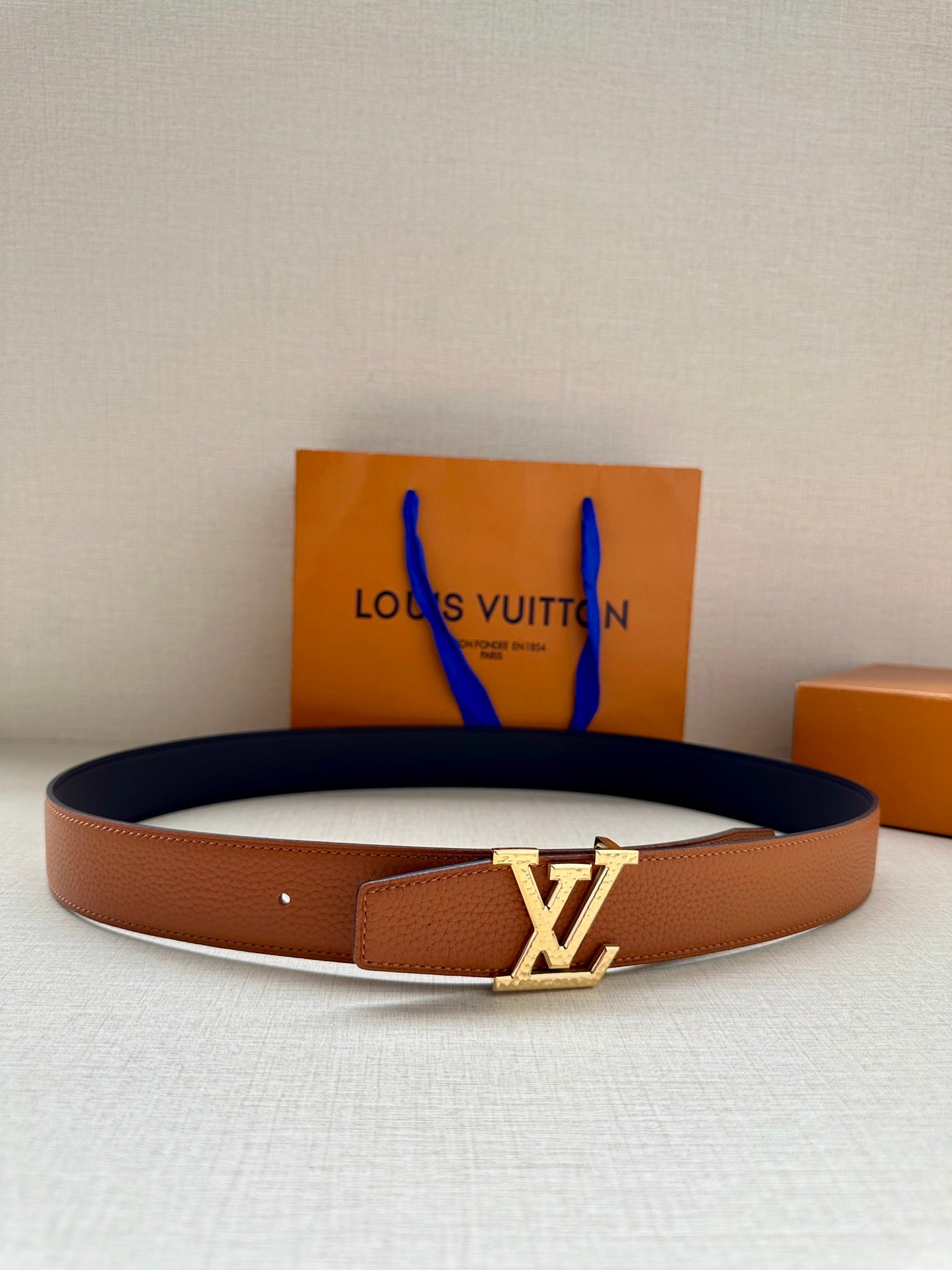 Louis Vuitton leather belt, tan strap with gold LV buckle and pin holes