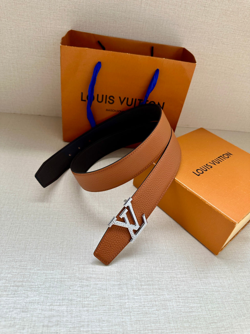 Louis Vuitton leather belt, tan strap with silver LV buckle and dark reverse
