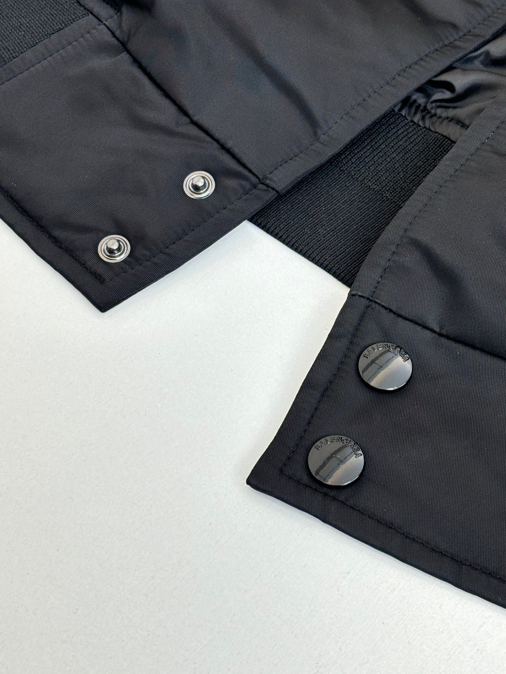 Dark navy bomber jacket close-up of snap buttons and ribbed inner cuff