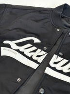 Dark navy bomber jacket with white 'Balenciaga' embroidered logo stripe and snap details