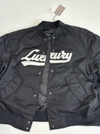 Dark bomber jacket with button placket, chest pockets, and white cursive logo