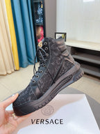 Dark high-top sneakers with lace-up closure and patterned upper, chunky outsole.