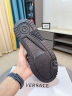 Black sneaker outsole with circular tread pattern and Versace branding on bottom.