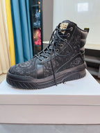 Dark high-top lace-up sneakers with allover logo pattern and thick tread sole.