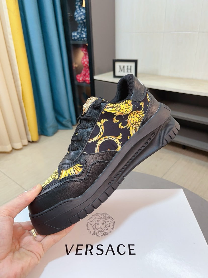 Versace platform sneaker in dark with gold baroque motif, angled side view