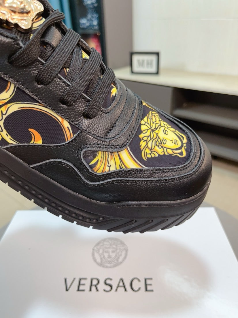 Versace platform sneaker close-up: dark leather with gold baroque pattern and laces