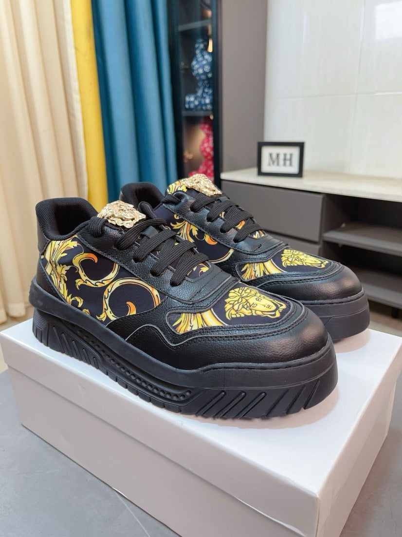 Versace platform sneakers in dark with gold baroque motifs, side view on display