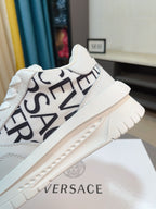 Versace white sneaker with diagonal black logo lettering and beige platform sole