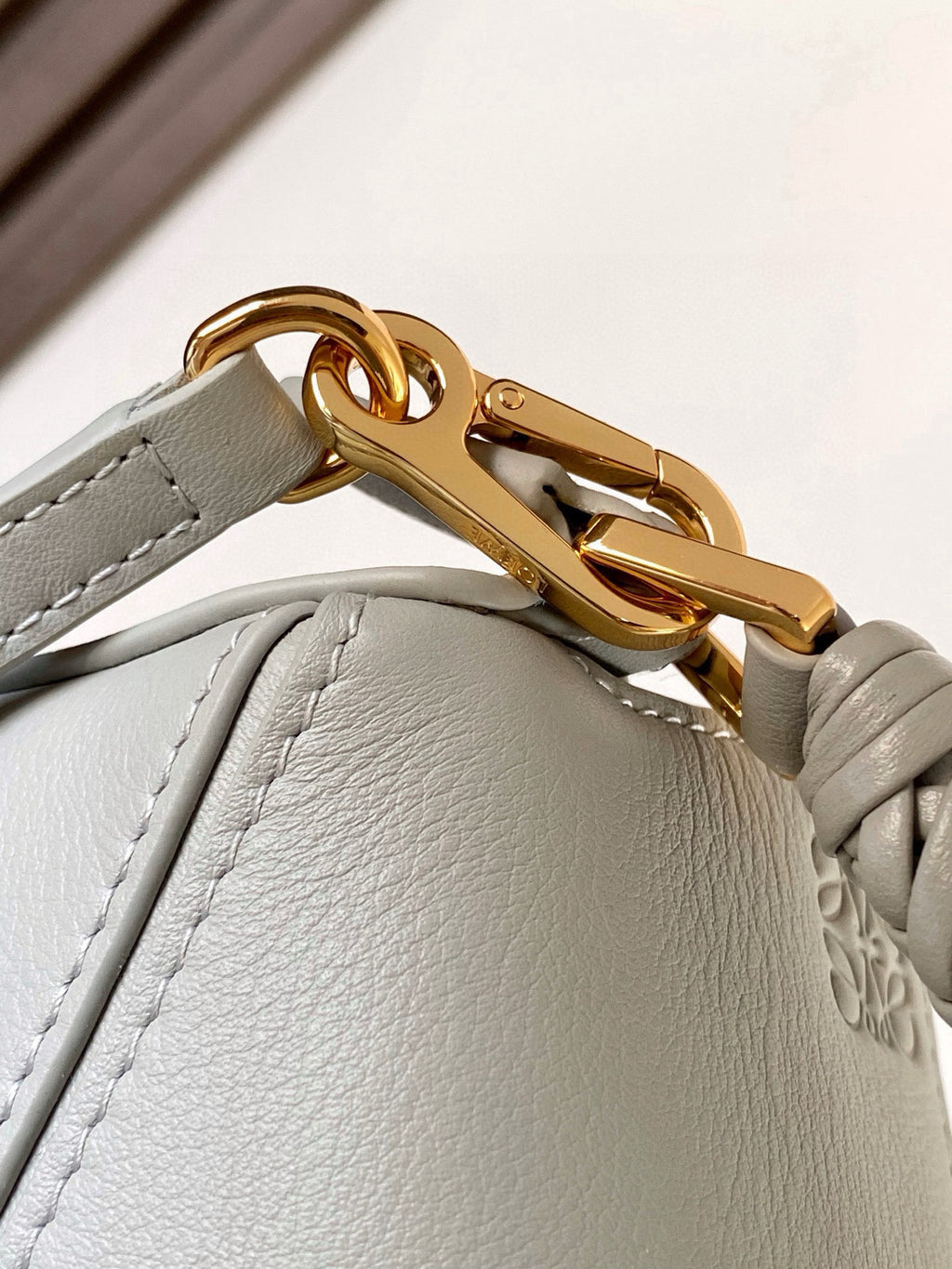 Light blue bag with gold turn-lock clasp and braided strap detail