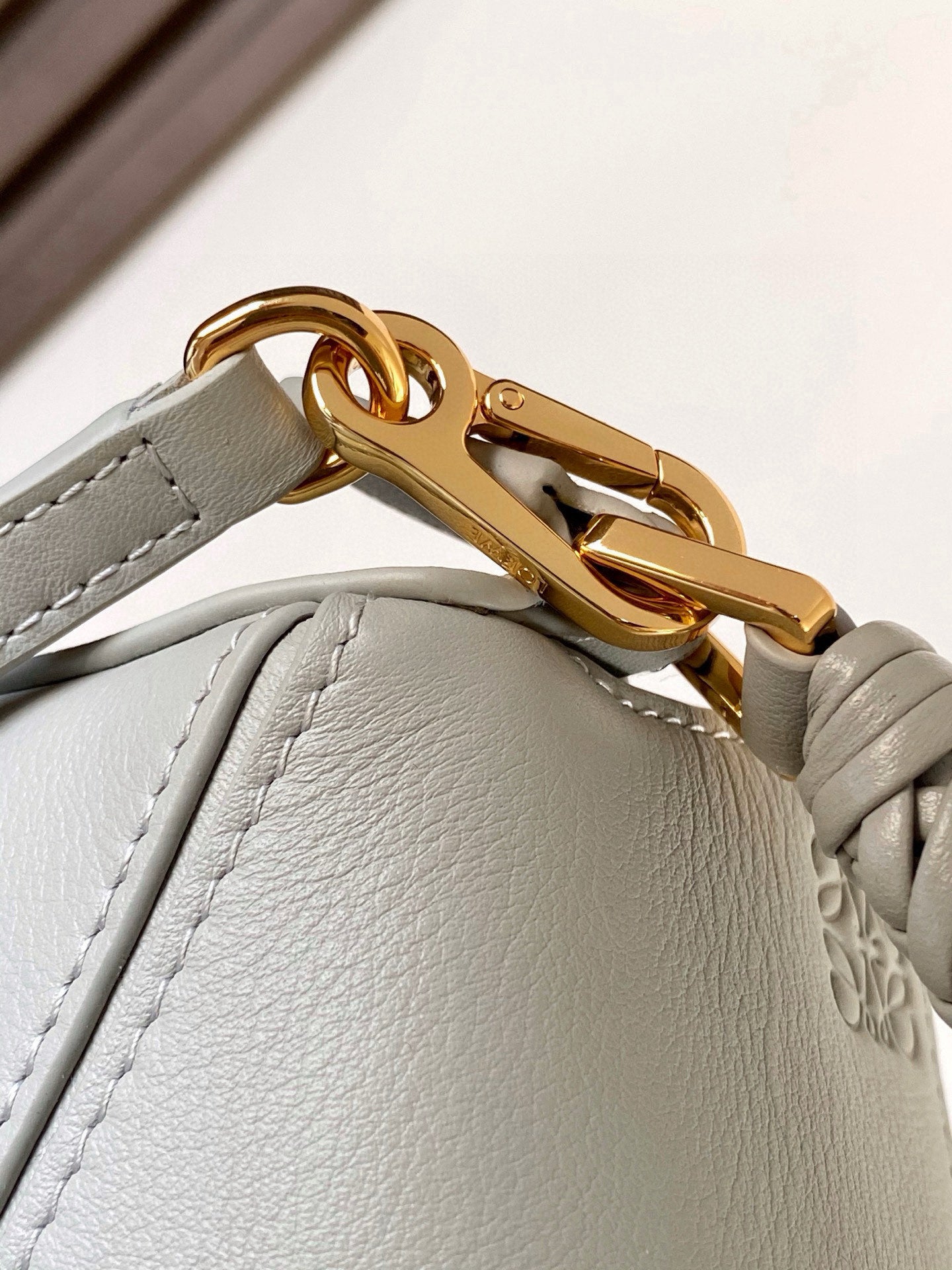 Light blue bag with gold turn-lock clasp and braided strap detail