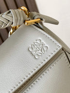 Light blue leather crossbody bag with embossed emblem and gold hardware
