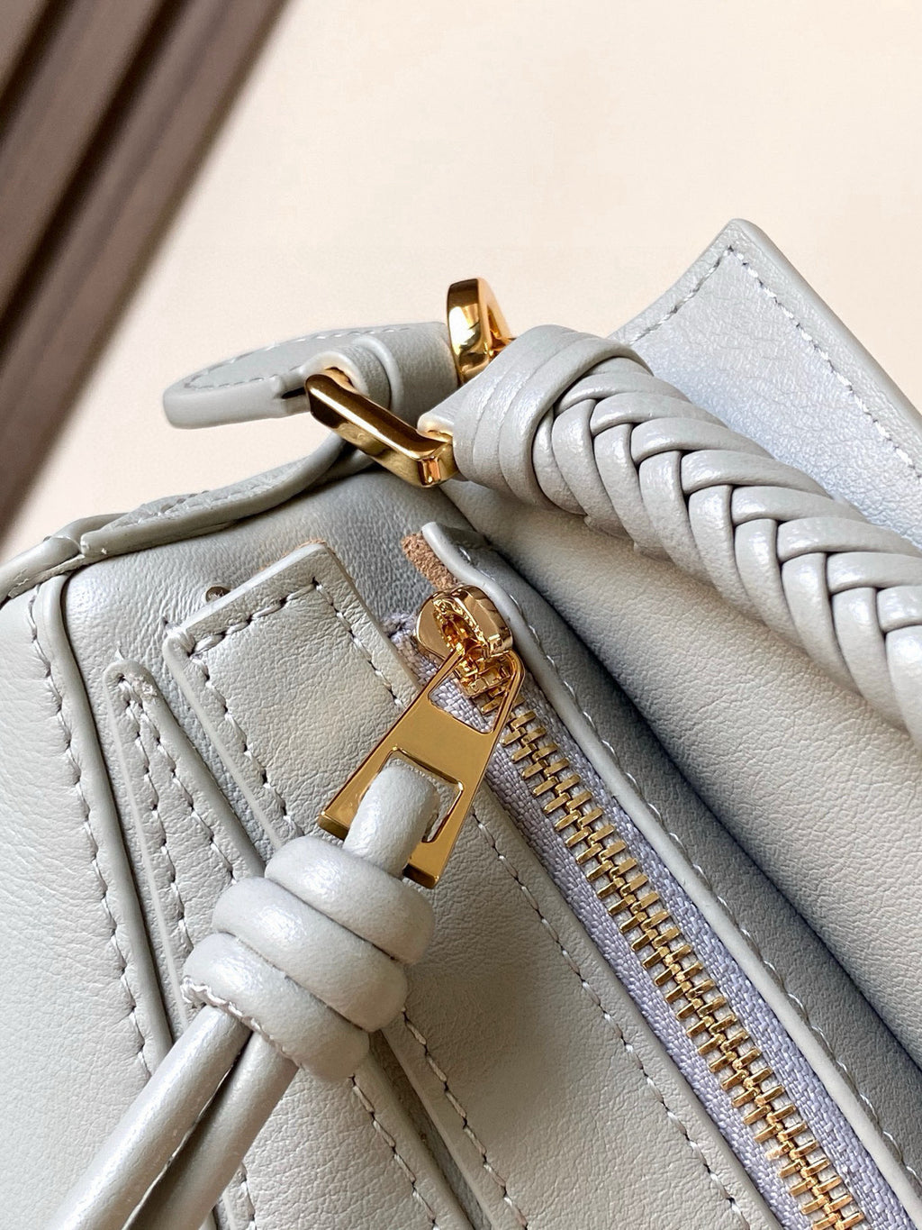 Light blue crossbody bag zipper track with braided trim and gold pull