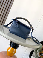 Blue leather crossbody bag with braided top handle and long strap