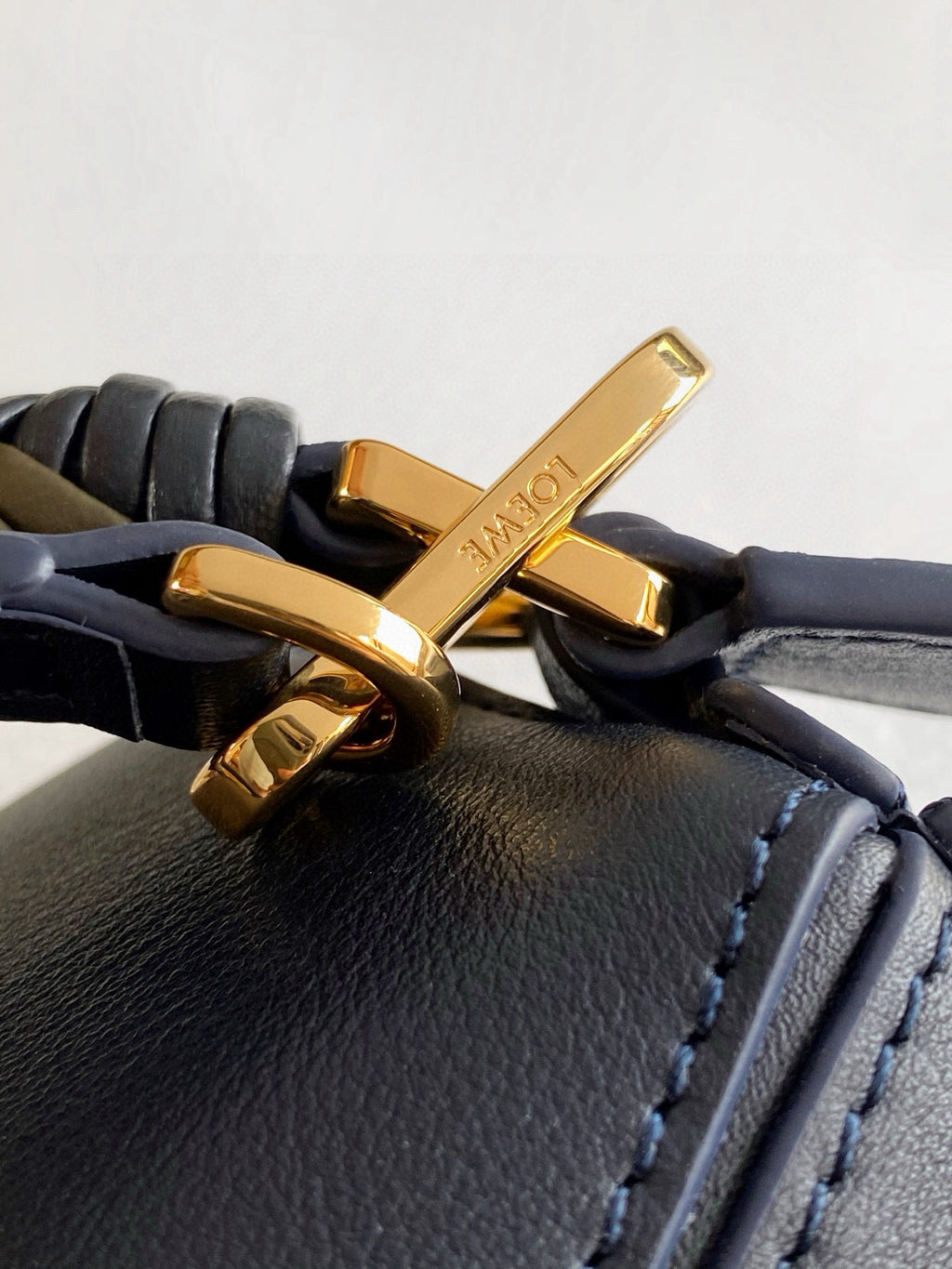 Blue leather bag flap with gold-tone metal buckle closure and strap