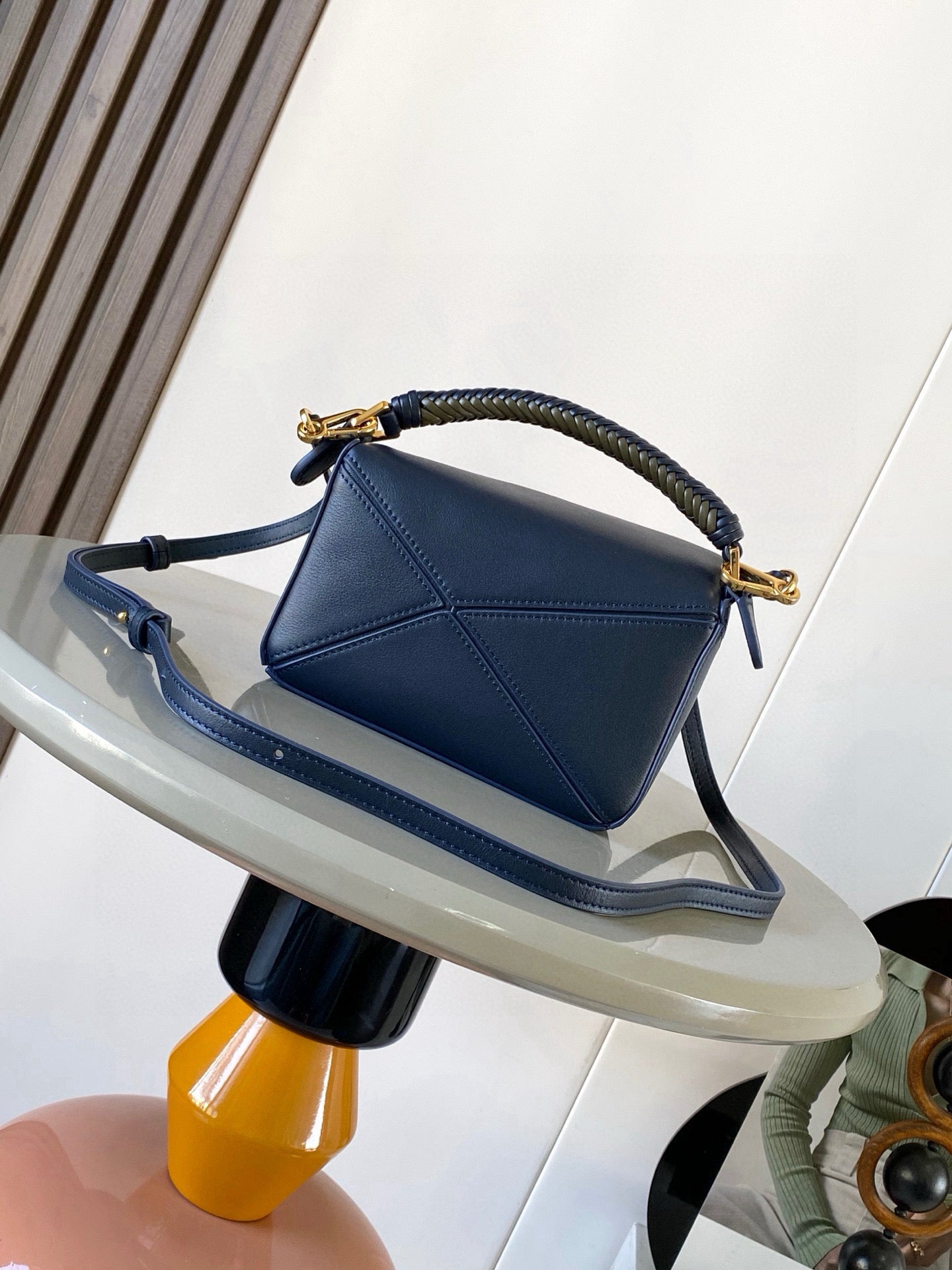 Navy leather bag with braided handle, gold-tone clasp hardware, and strap