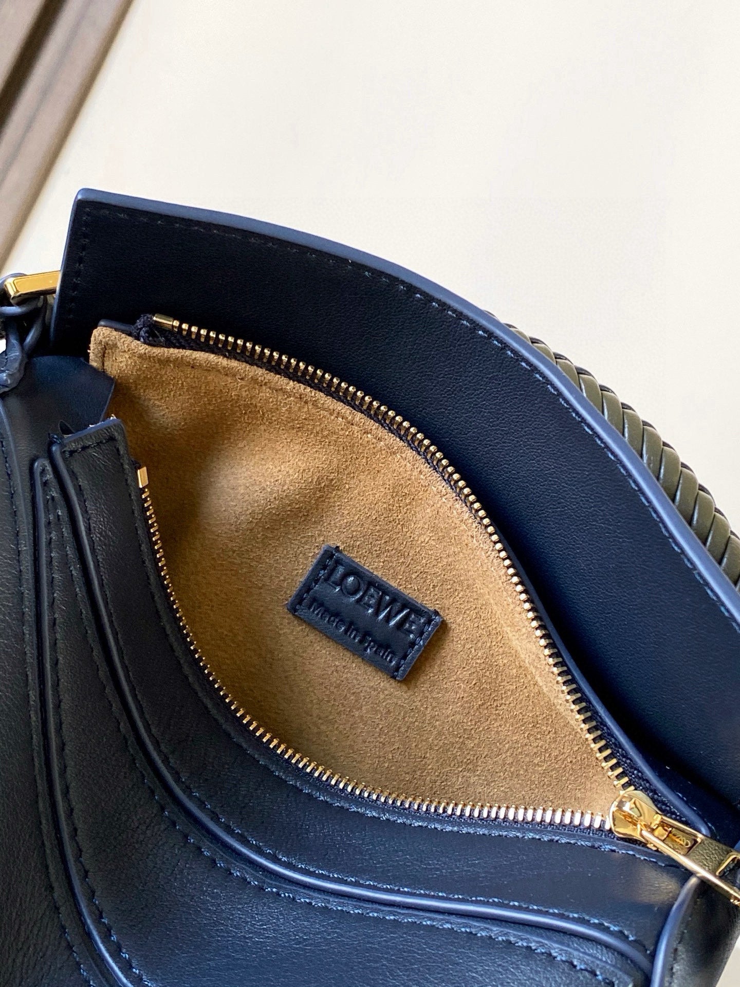 Navy leather bag interior with Loewe logo patch and gold zipper opening