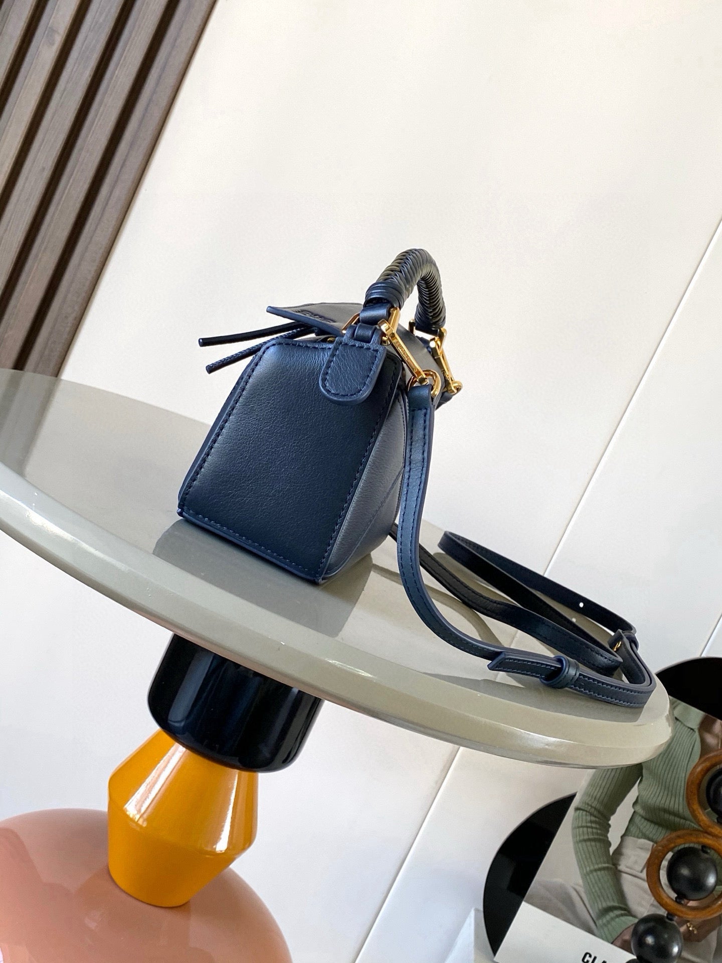Blue leather handbag with shoulder strap and gold-tone clasp hardware
