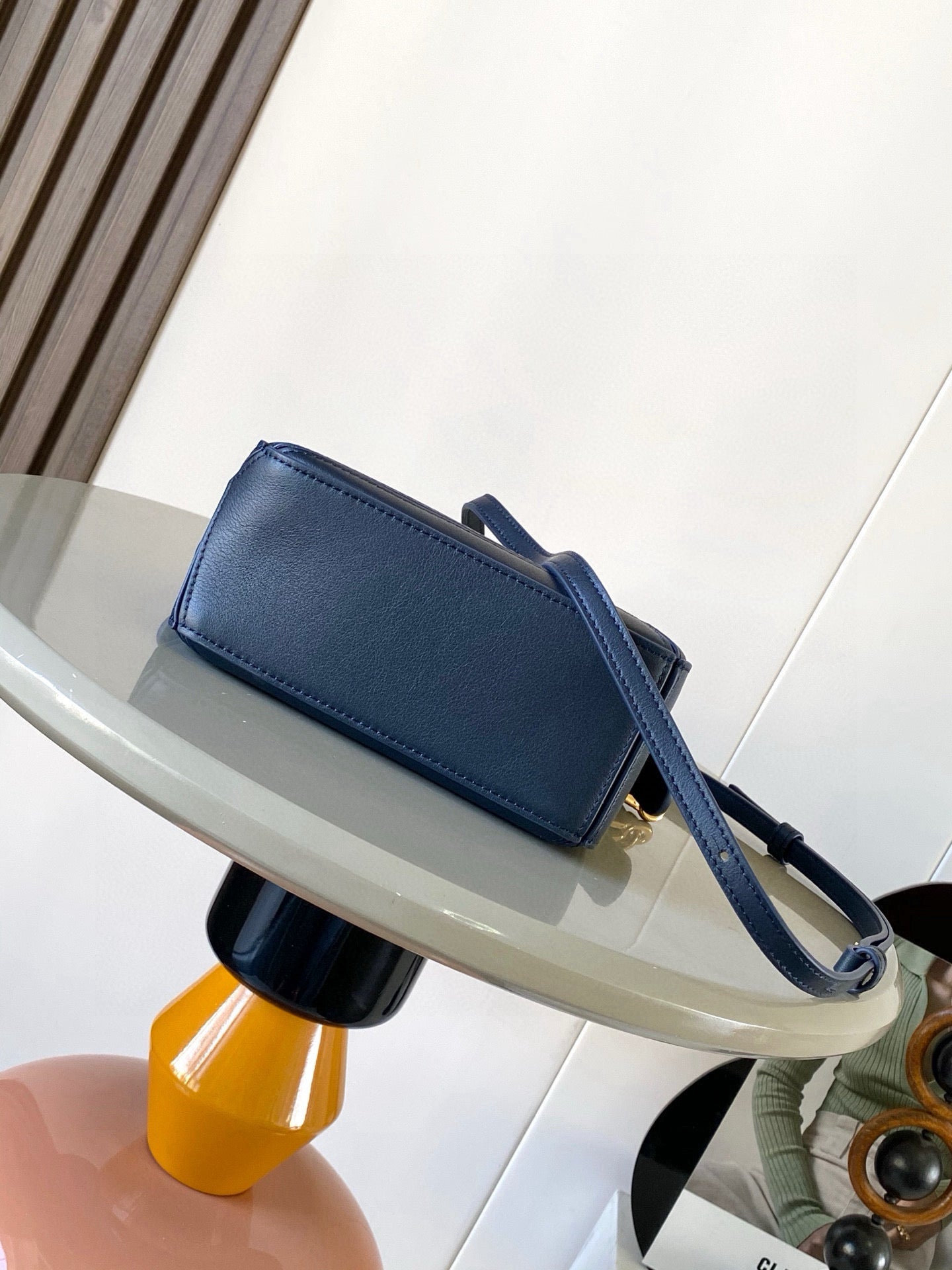 Blue leather crossbody bag with side strap and gold zipper pull