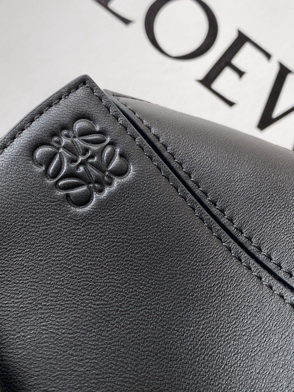 Loewe leather bag panel with embossed clover logo and contrast stitching in dark navy