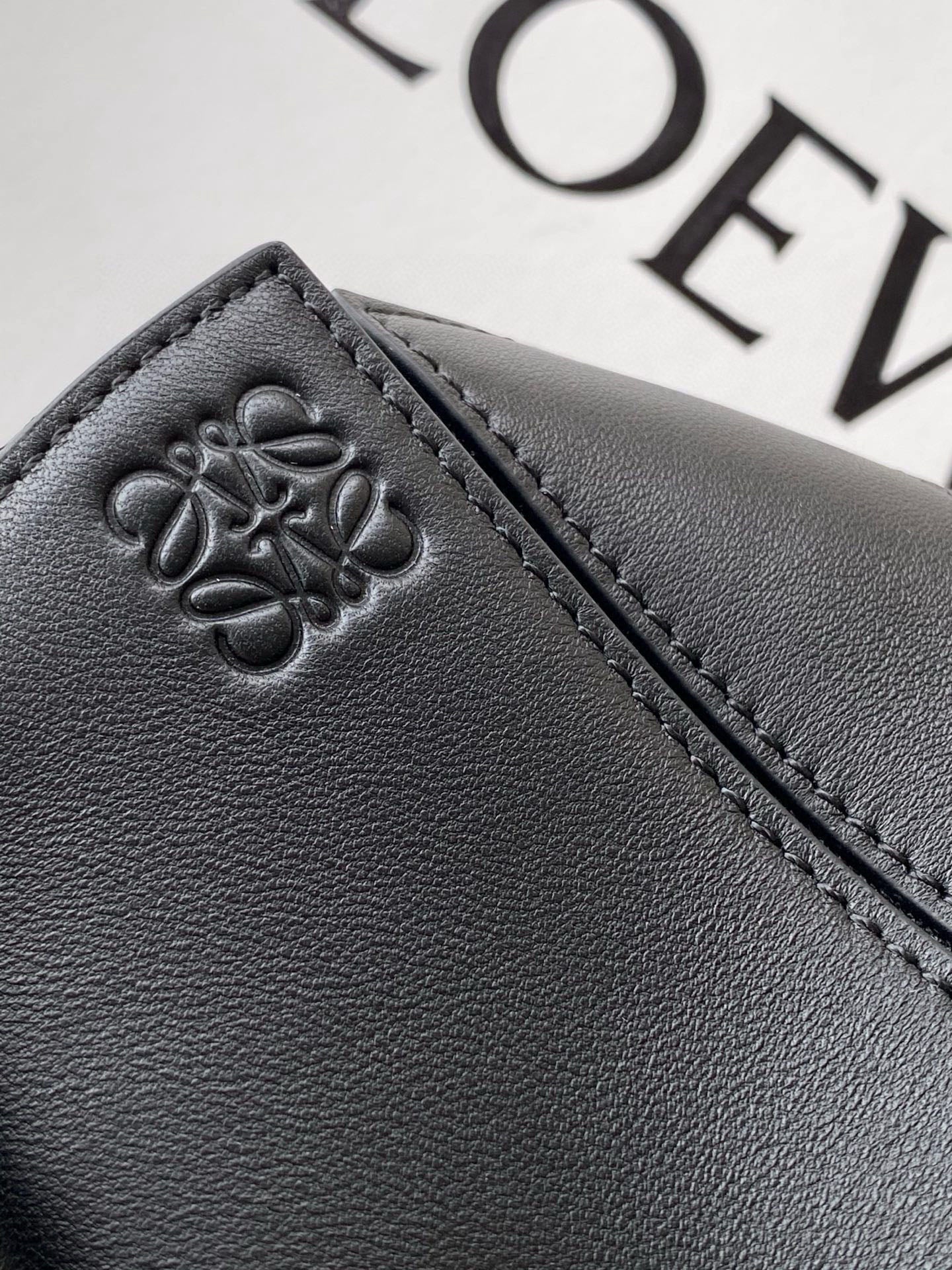Loewe leather bag panel with embossed clover logo and contrast stitching in dark navy