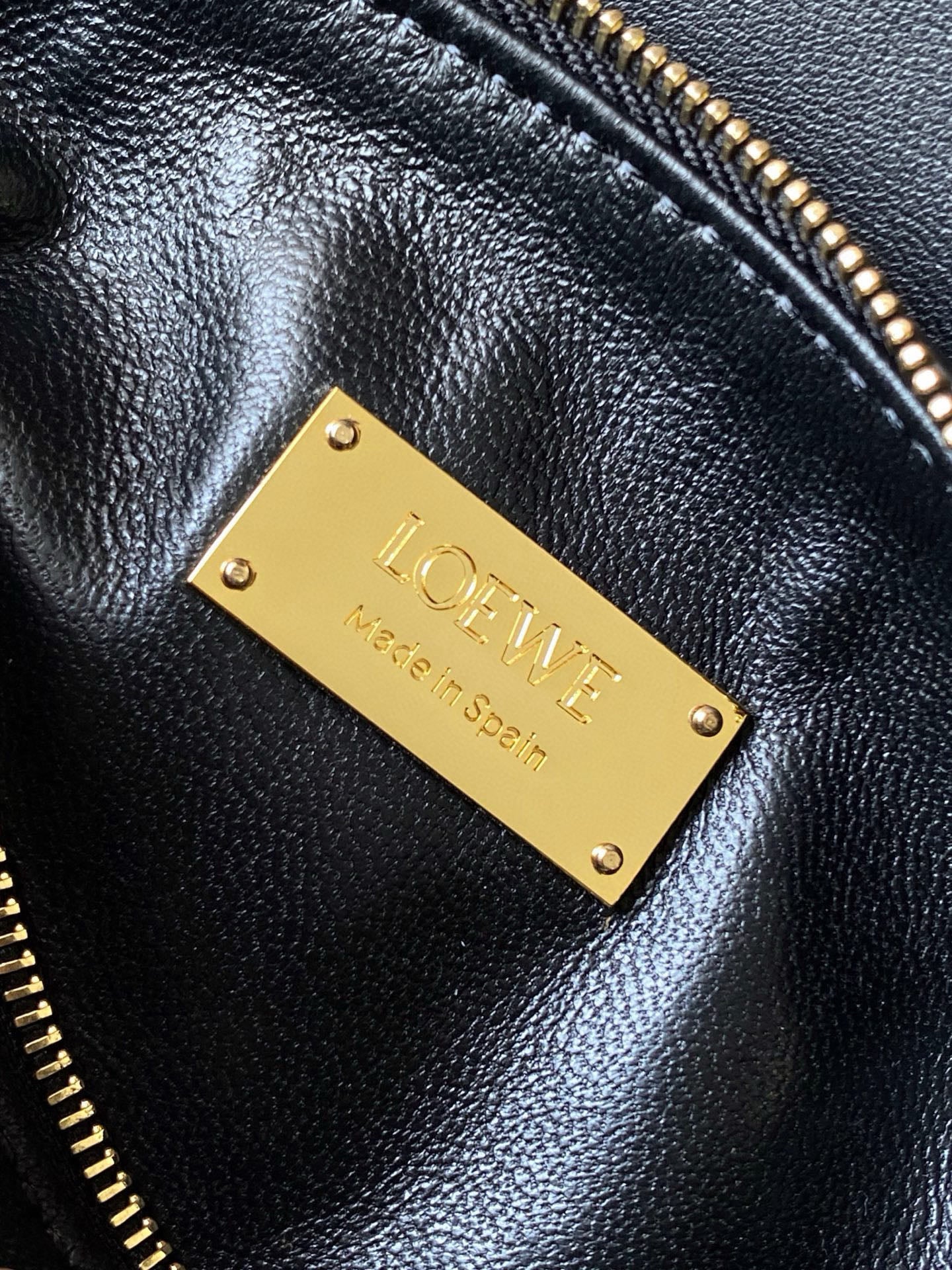 Loewe men’s black leather bag with gold LOEWE nameplate and riveted hardware.
