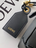 Loewe leather key holder charm in dark gray with gold “LOEWE” lettering