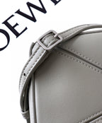 Light gray Loewe leather bag close-up of top edge, strap stitching, and buckle