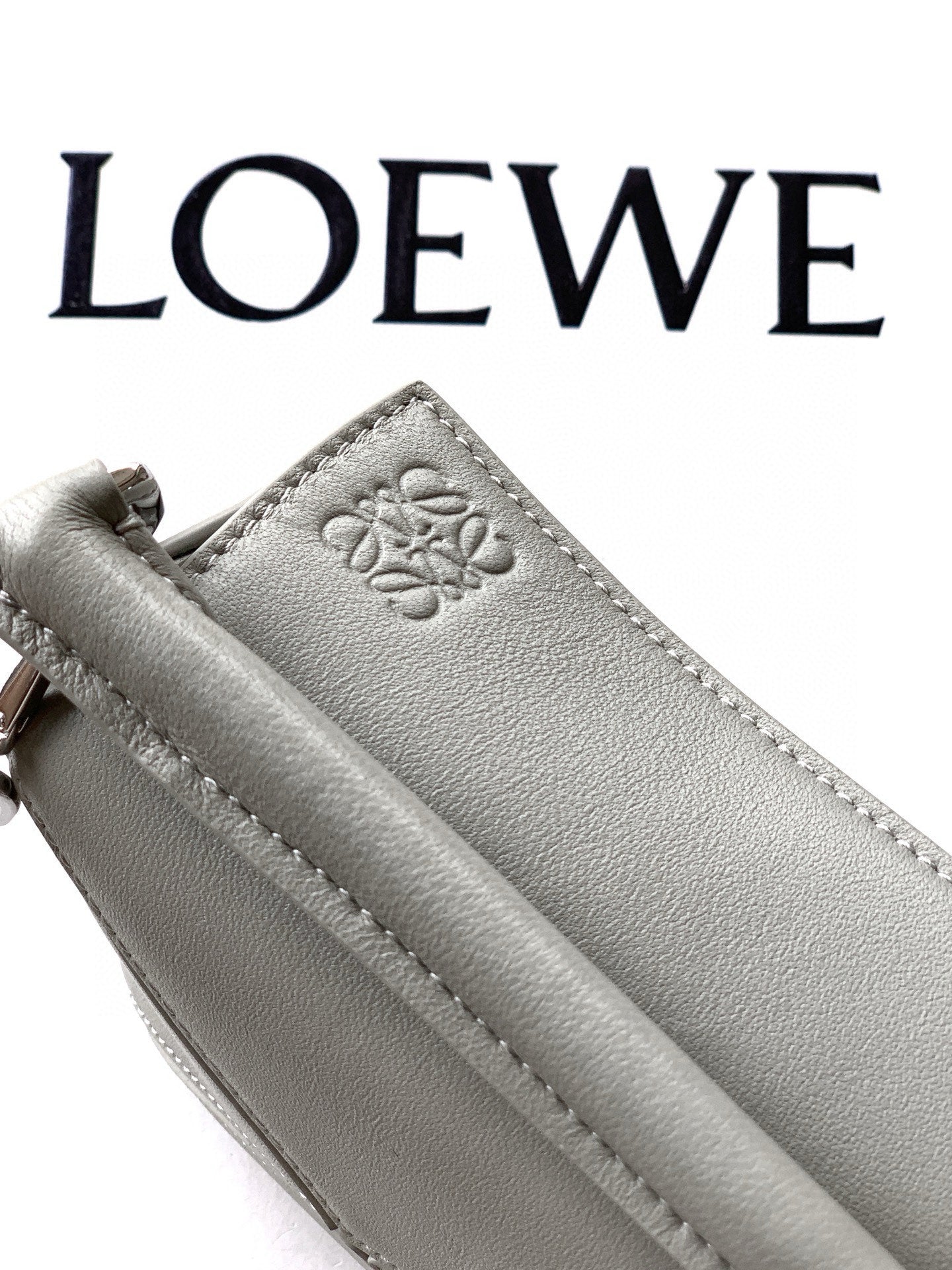 Gray Loewe leather key pouch with embossed logo paw and side strap loop
