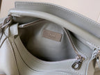 Light gray leather bag interior with Loewe logo plaque and zipper opening