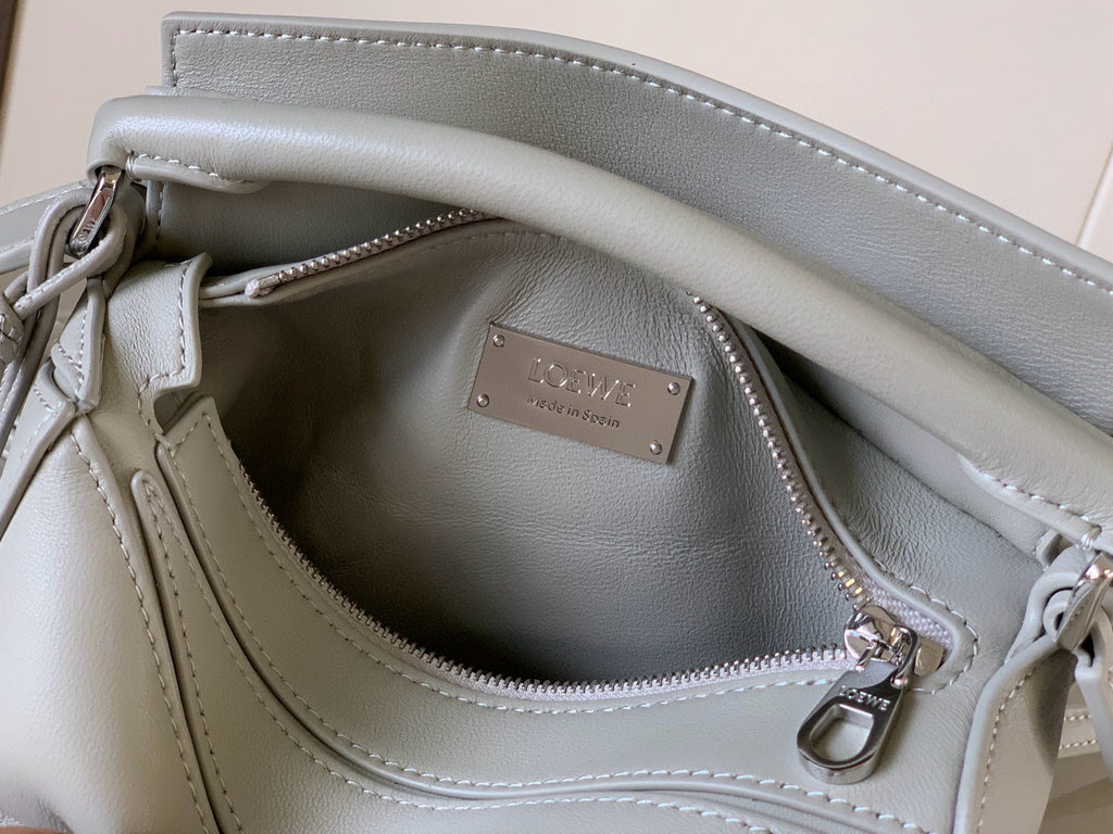 Light gray Loewe leather bag interior with logo plaque and zip pocket
