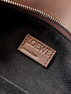 Leather bag lining label with LOEWE branding near zipper, dark taupe