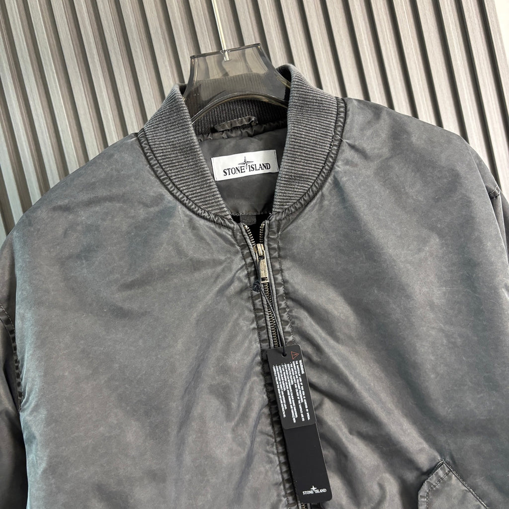 Stone Island bomber jacket close-up: dark gray knit collar and front zip with labels