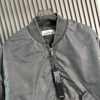 Stone Island bomber jacket close-up: dark gray knit collar and front zip with labels