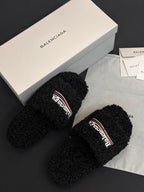 Black fuzzy slide sandals with Balenciaga logo strap, side view