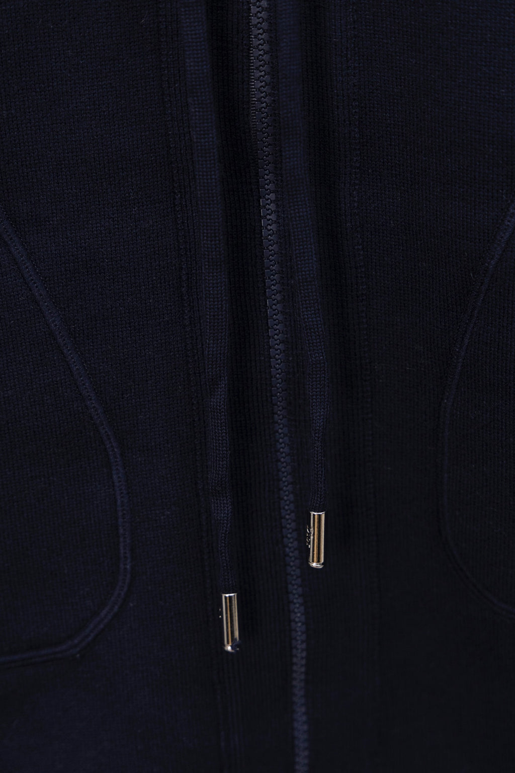 Navy zip-up hoodie front close-up, zipper track with metal pulls