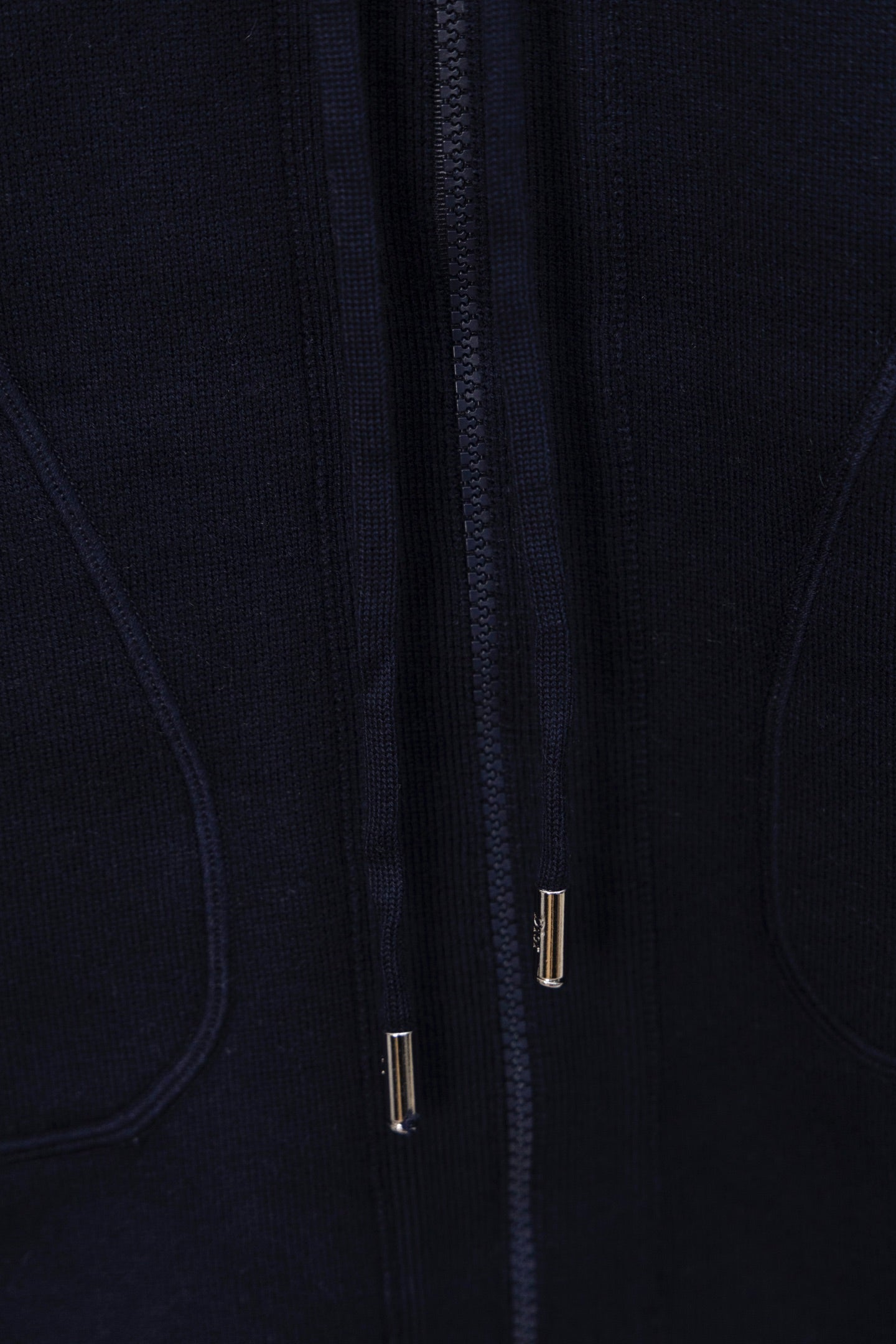 Navy zip-up hoodie front close-up, zipper track with metal pulls