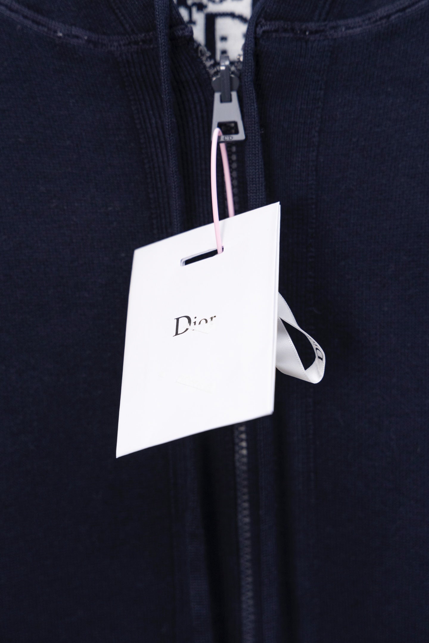 Navy hoodie close-up of front zipper and Dior hang tag