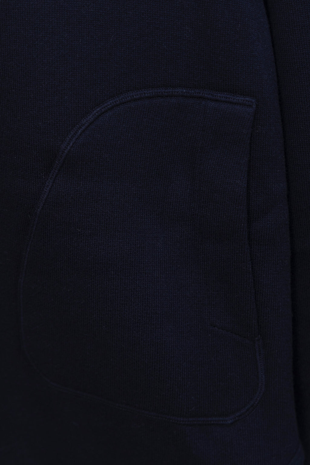 Navy hoodie chest pocket close-up, smooth knit fabric