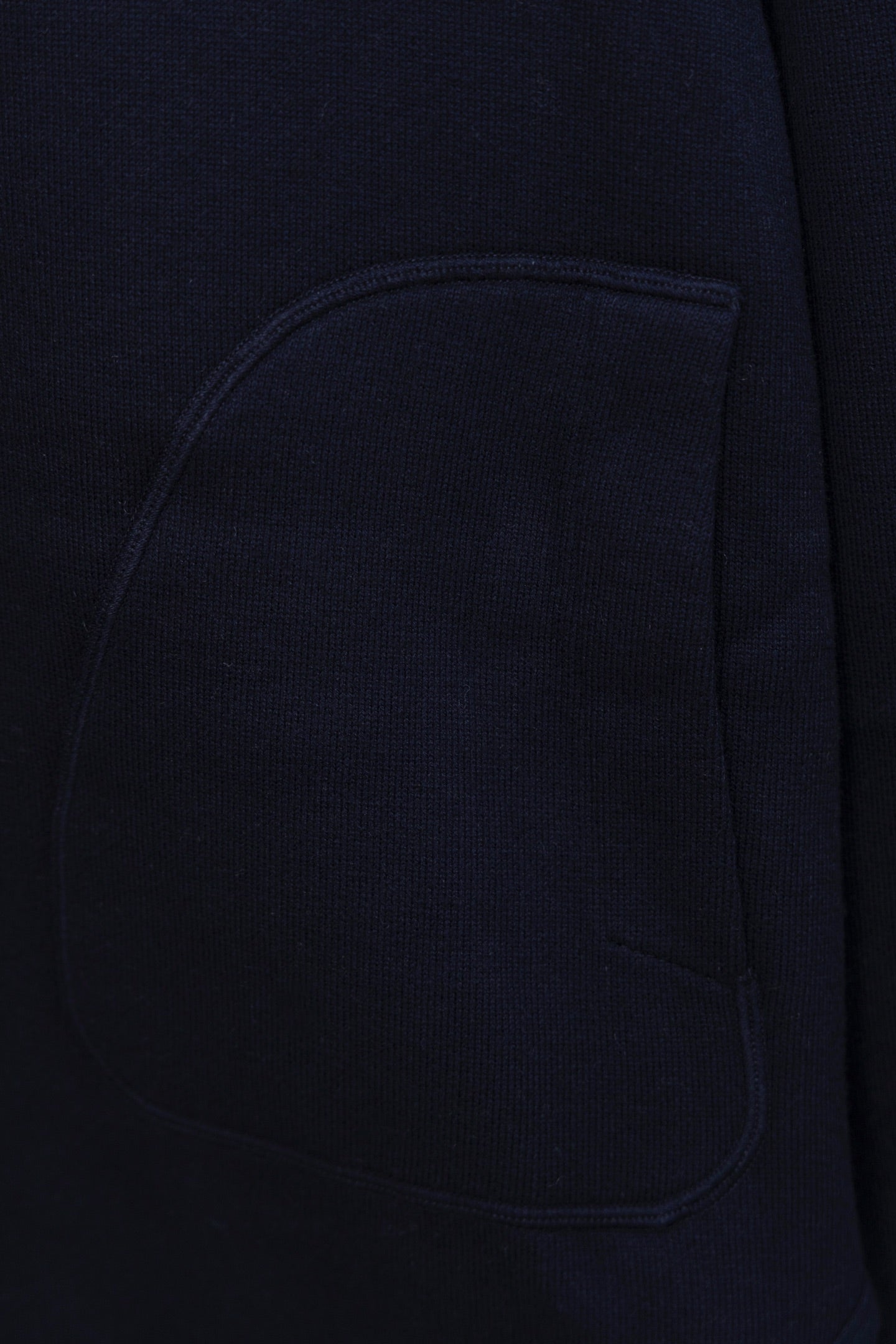 Navy hoodie chest pocket close-up, smooth knit fabric
